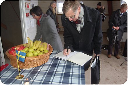En ledningsperson på Götene kommun signerar en bok i utsiktstornet.
