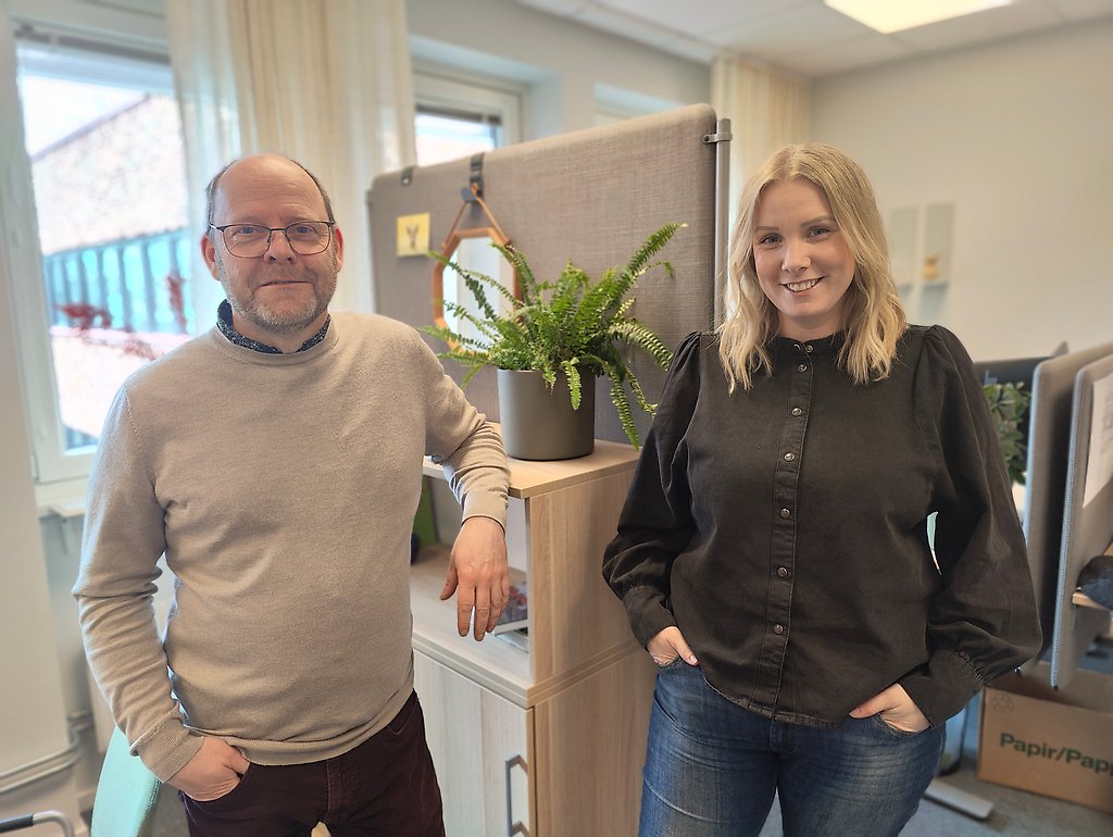 Bygglovshandläggare Christer Hjälm och Camilla Brandell står i ett rum och ser glada ut. 