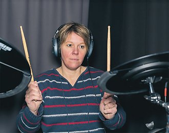 Kvinna som spelar trummor.