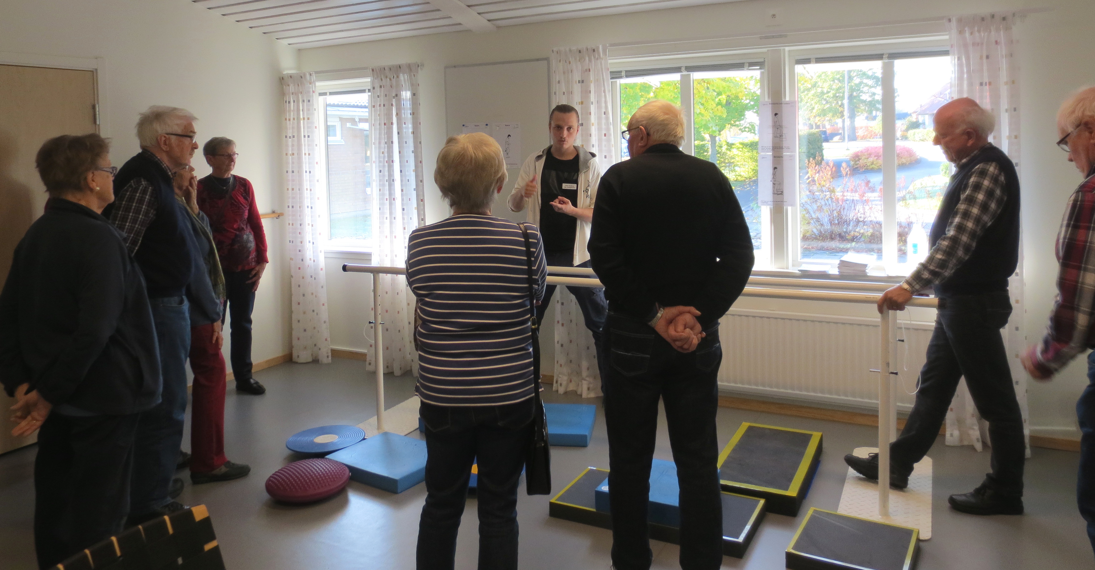 En grupp äldre människor tittar på balansutrustning.