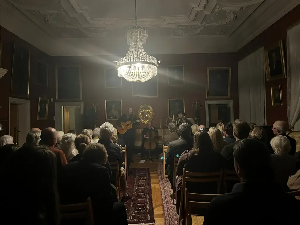 Ett band som spelar i en sal framför en publik.