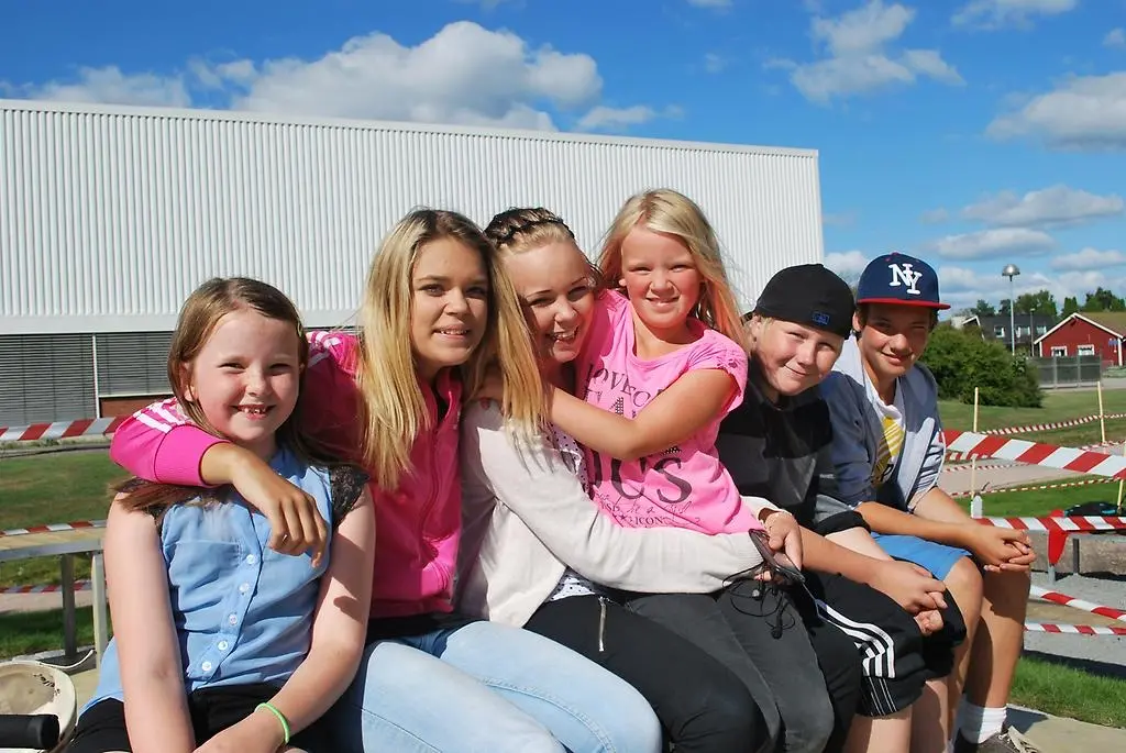 Ett gäng ungdomar som sitter i en hög på skatparken.