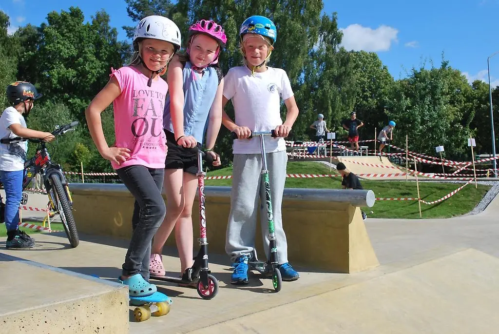 Tre tjejer på sparkcyklar.