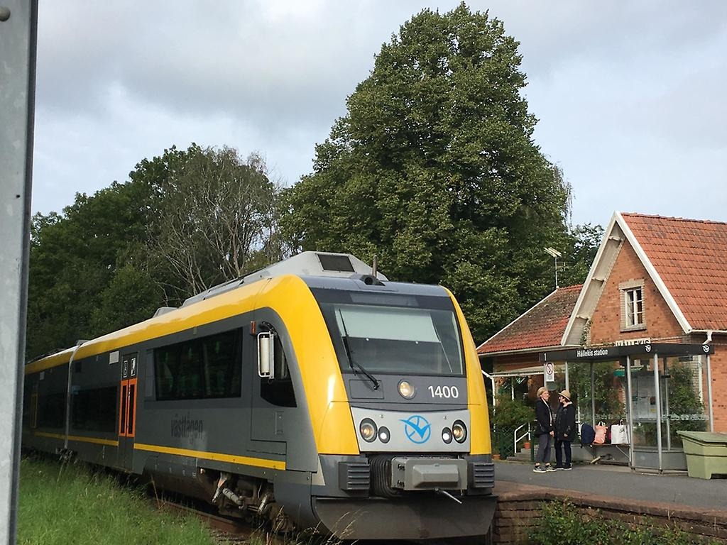 Ett tåg vid en tågstation med människor som kliver av tåget.