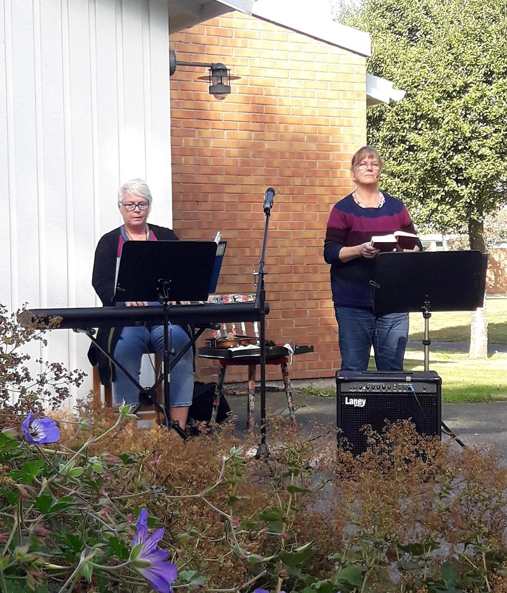 Två kvinnor, en sitter vid ett piano och den andra står och håller i en uppslagen bok.