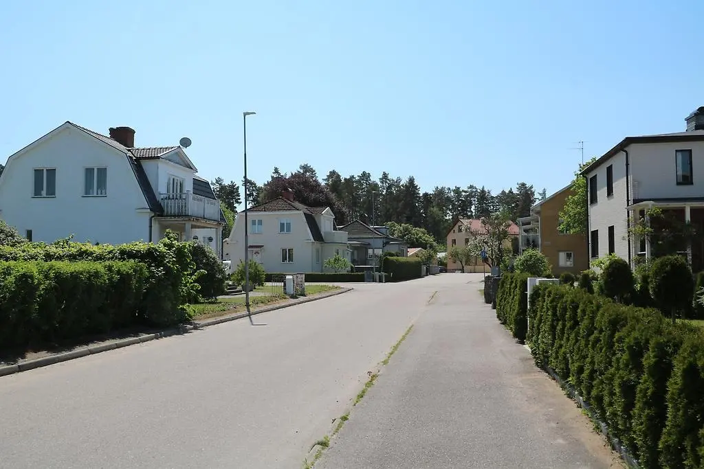 En bild som visar flera villor längs en gata i ett bostadsområde.