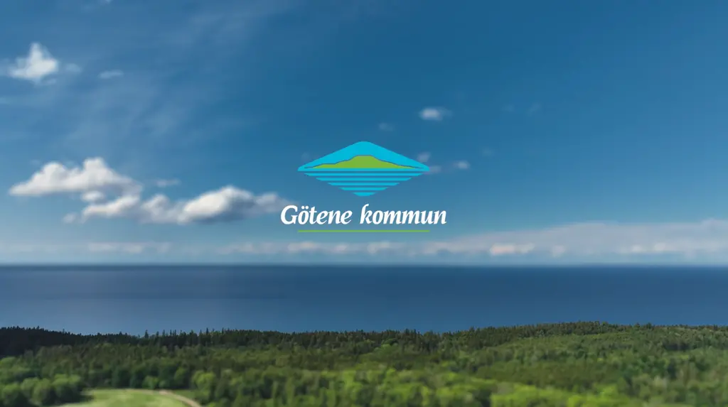 Flygbild över Kinnekulle med Vänern i bakgrunden med Götene kommuns logotyp mitt i bilden.