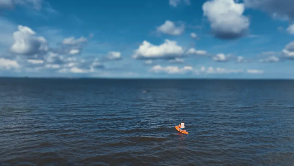 En vuxen och ett barn som paddlar på en standup padelboard på Vänern.