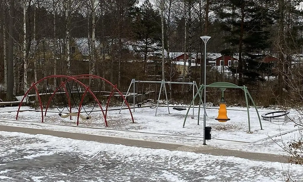 Gungor på en snötäckt lekplats.