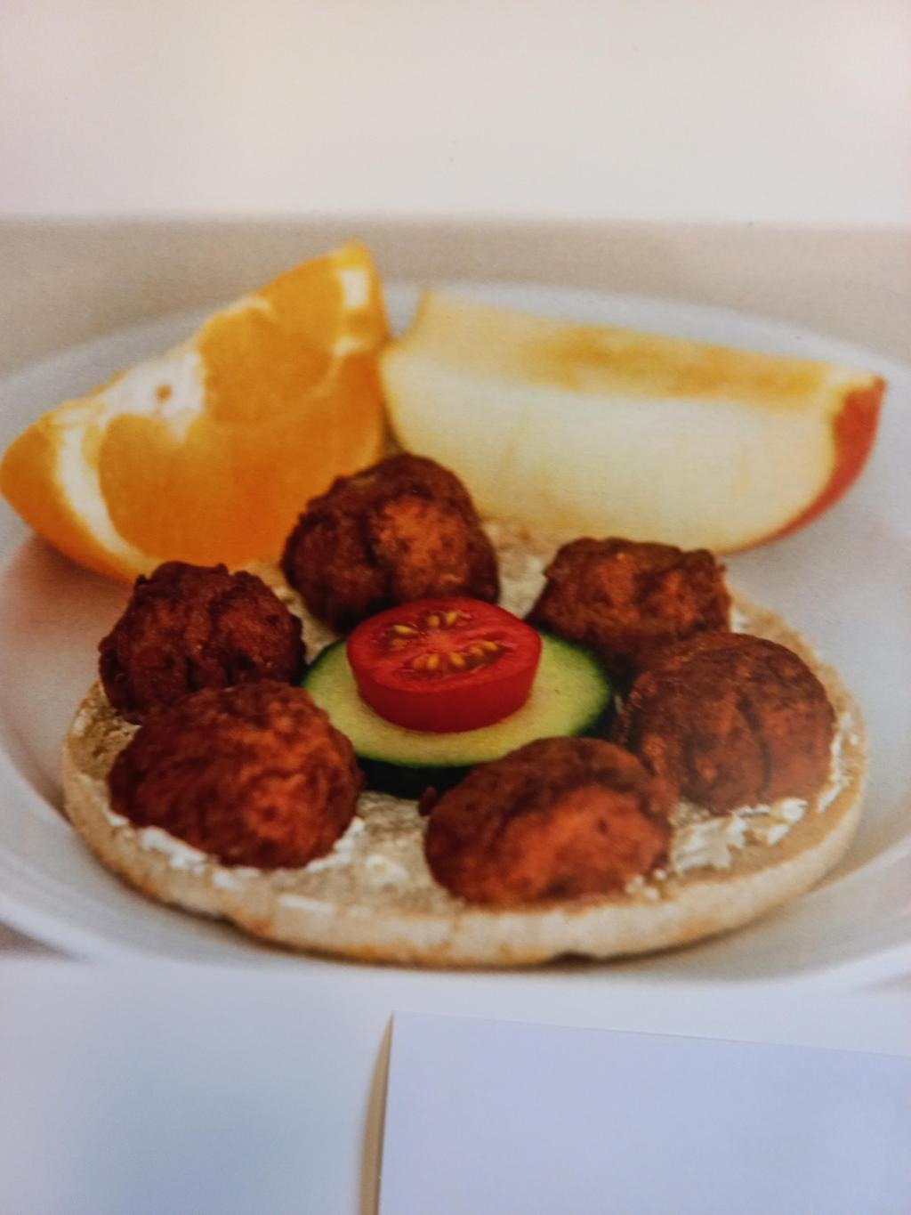 Bild på en köttbullesmörgås, en apelsinklyfta och en äppelklyfta.