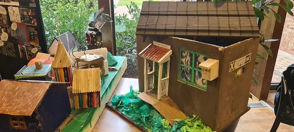 Hus och miljöer i kartong, som förskolebarn tillverkat.