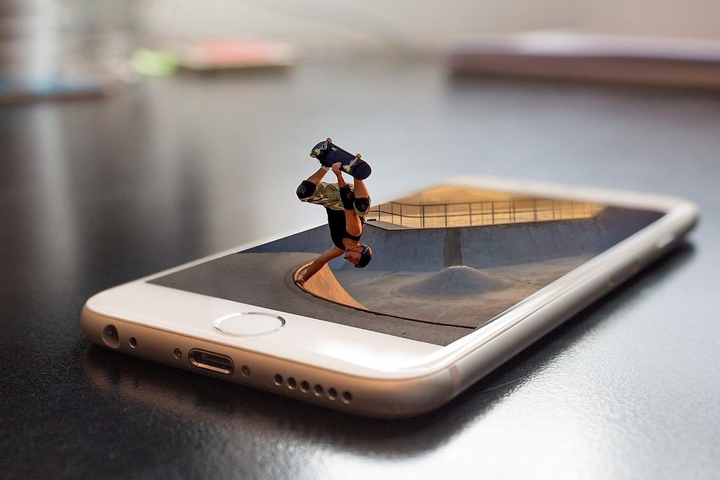 En stor liggandes mobiltelefon, där en skejtare gör ett trix och åker ut ur mobilen