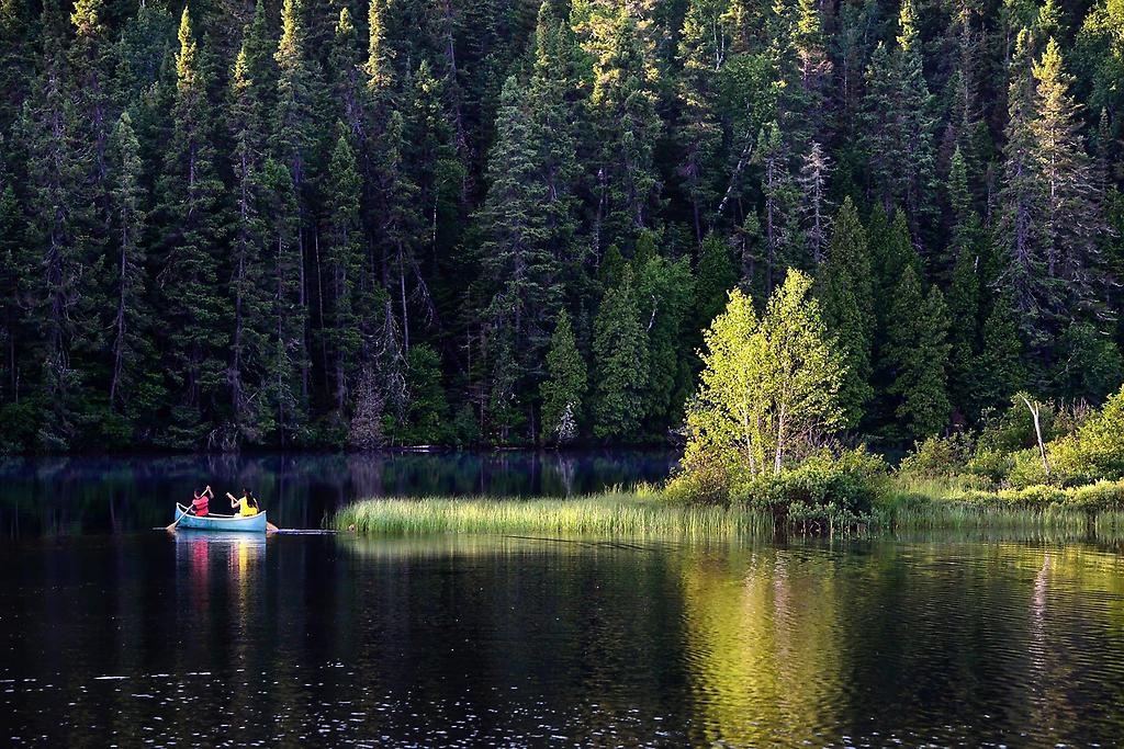 En sjö med 2 stycken som paddlar kanot