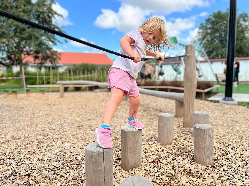 Barn som går balansgång på en lekplats.