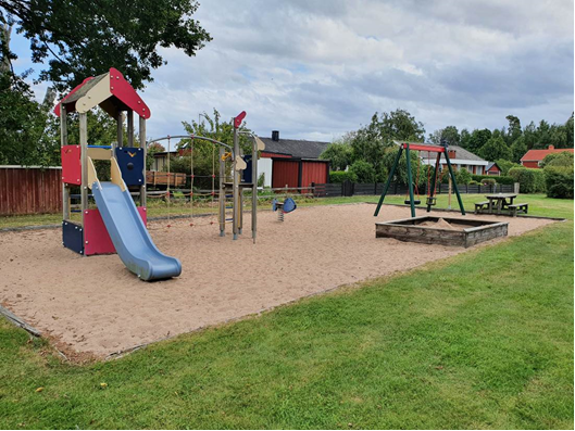 Lekplats med bland annat rutschkana, sandlåda och gungor. 