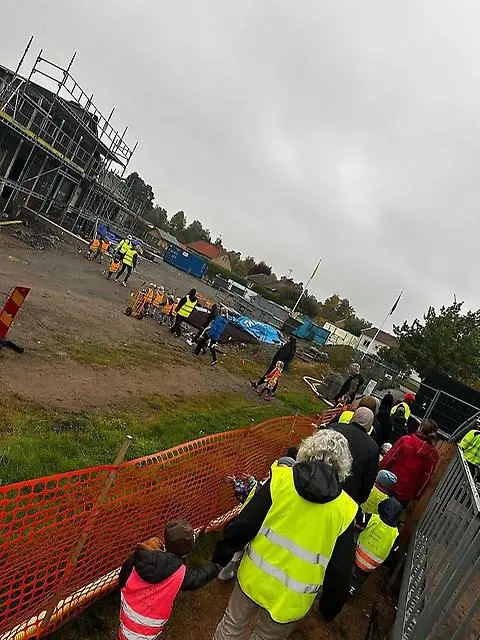 En lång rad av barn och lärare går in i bygget.