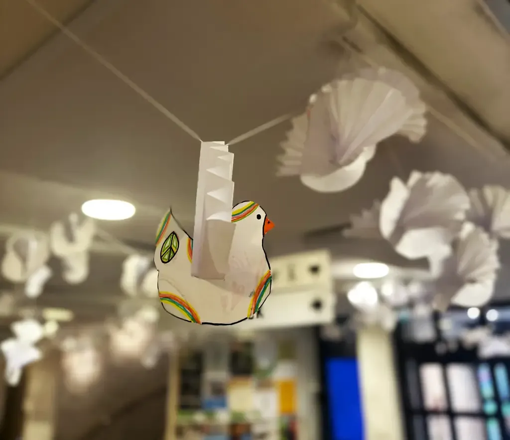 Ett hav av pappersduvor som hänger i taket.