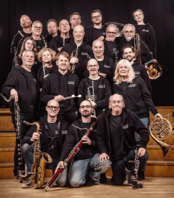 En stor grupp människor som håller i varsitt blåsinstrument.