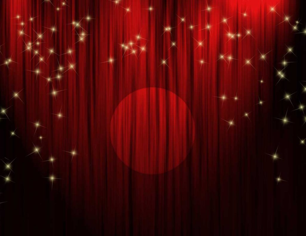 Rött draperi framför en teaterscen.