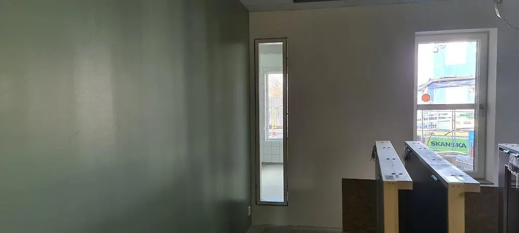 Ett långsmalt inomhusfönster från vilket förskolebarnen kan se in i skolans kök.