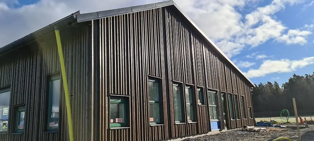 Gavel på byggnad. Färgen är brun. Solen skiner.