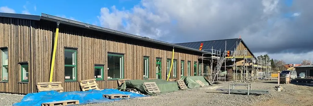 En brun stor förskolebyggnad som börjar ta form. 