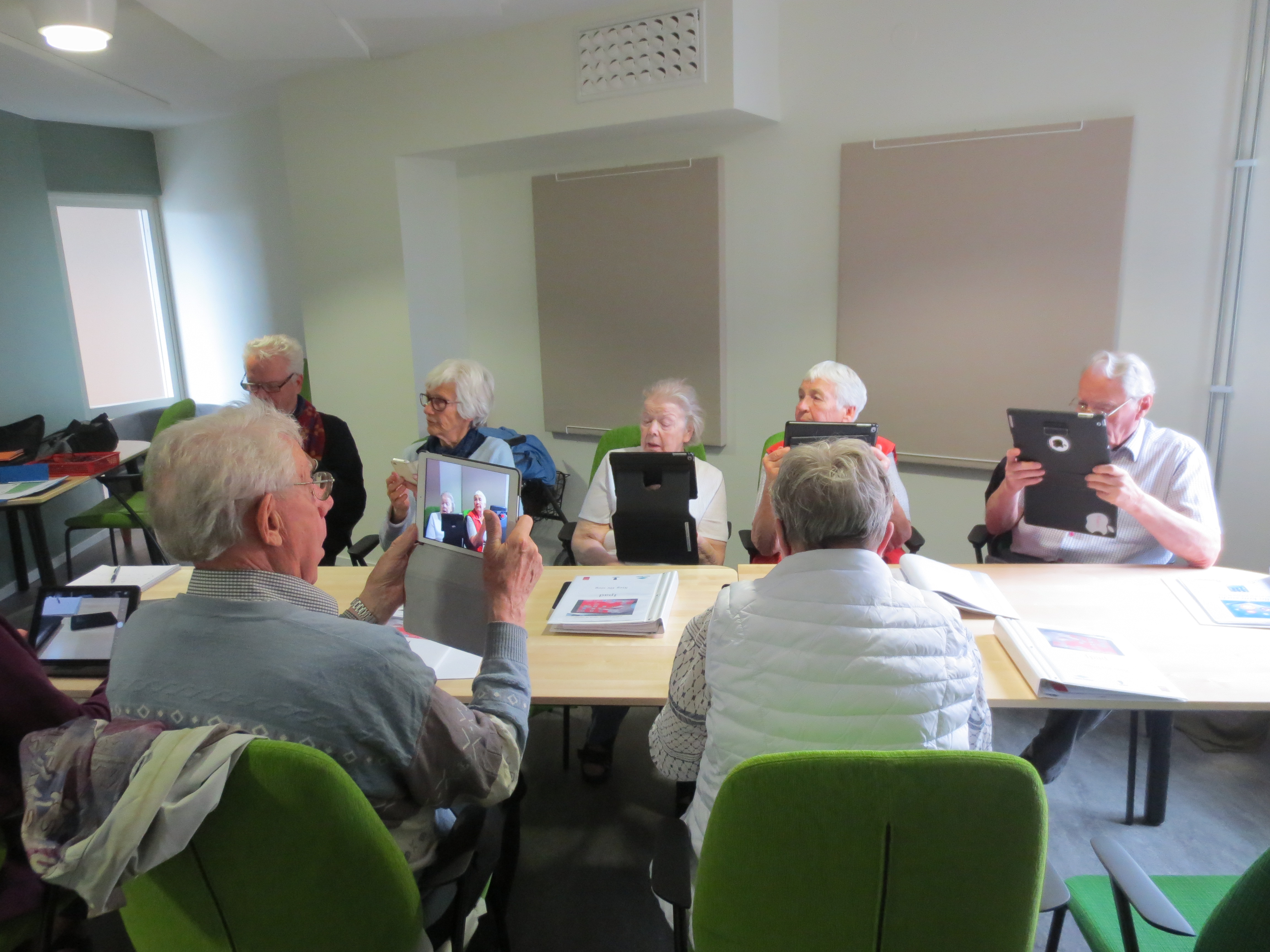 Engagerade seniorer lär sig fotografera med iPad