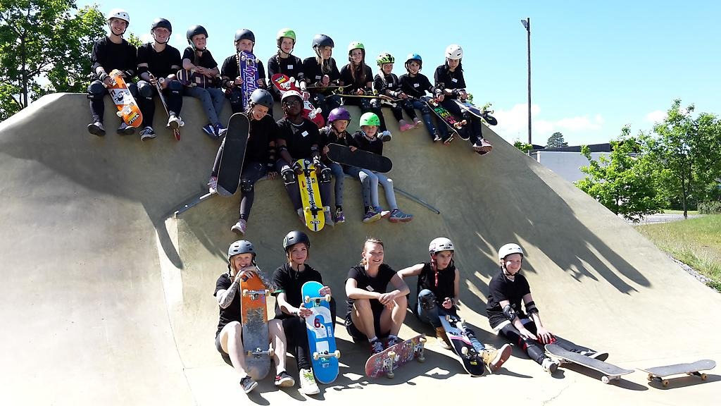 20-tal ungdomar som sitter i rampen med sina skateboards.