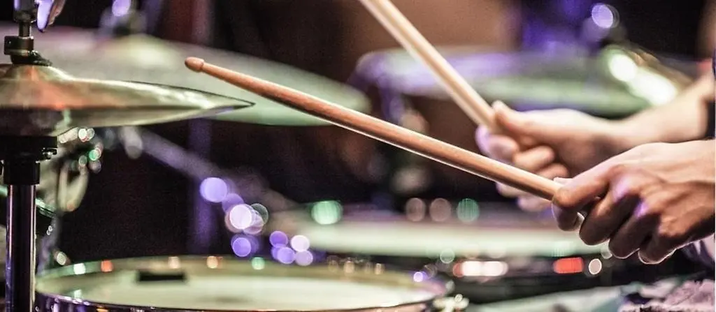 En person spelar på ett trumset.