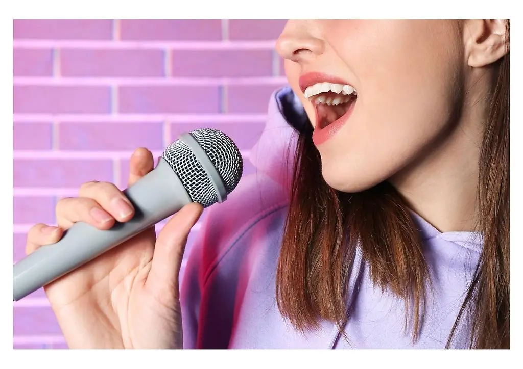 Tjej som sjunger i en mikrofon.