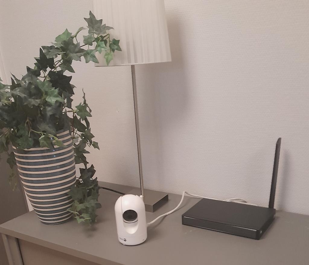 Bilden visar en tillsynskamera med sändare stående på en byrå