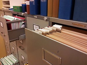 Arkivskåp med öppna lådor som innehåller handlingar.