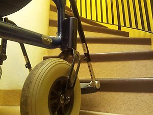 En rullstol som står nedanför en trappa.