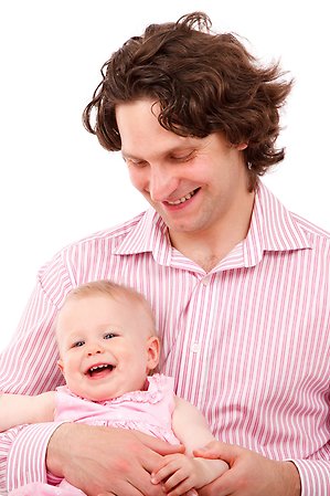 Pappa som håller i ett litet barn, de ser glada ut och ler