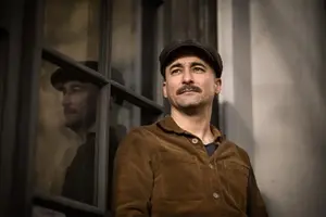 Författaren Erik Masao Eriksson står framför en vägg