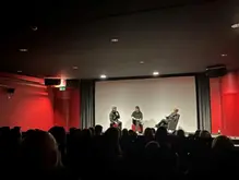 Tre personer på scen i ett samtal. 