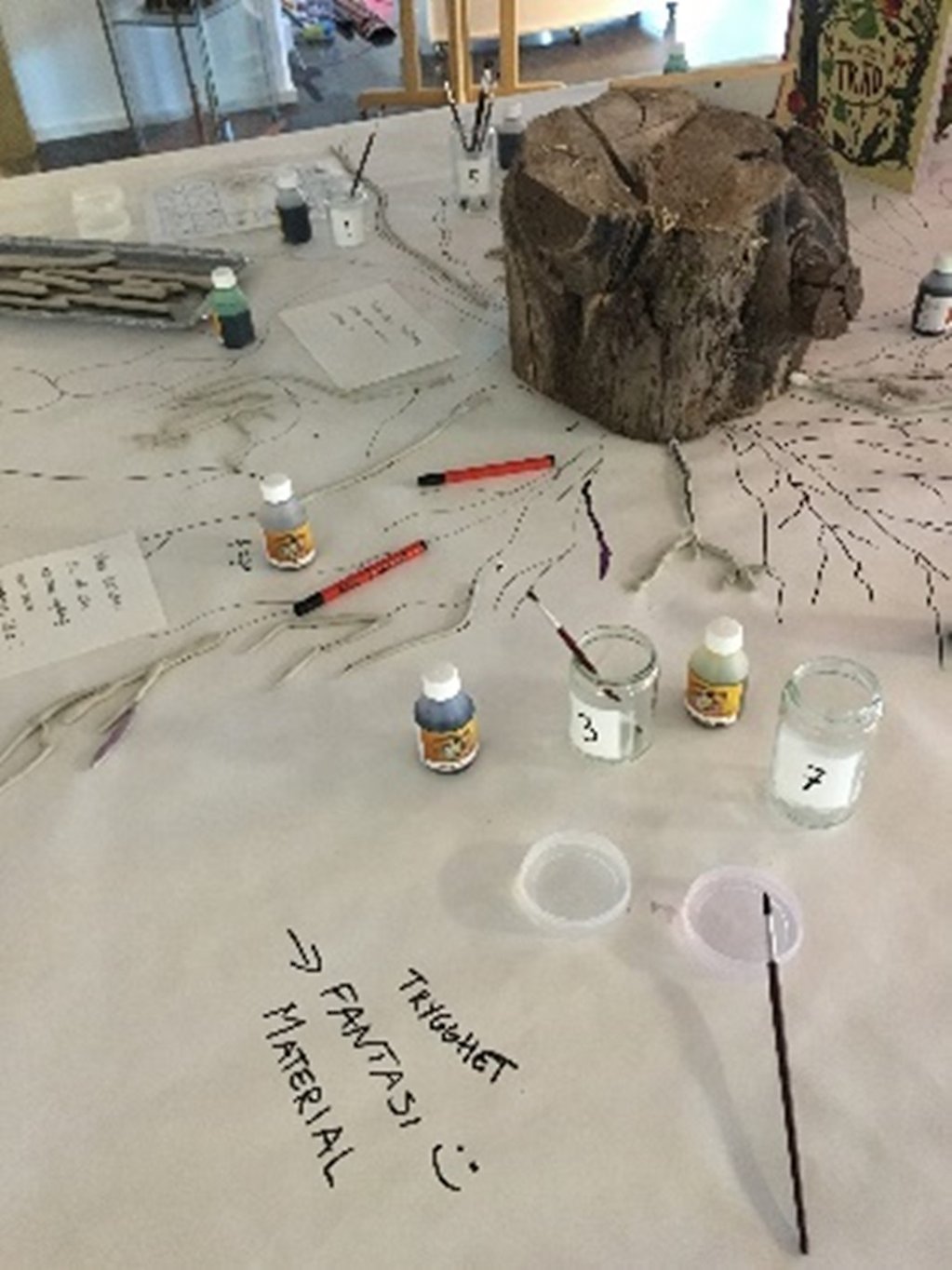 En gammal stubbe på ett bord och barnen har ritat stubbens rotsystem
