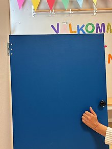 Bild på en hand som knackar på en blå dörr.