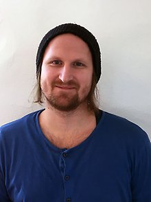 Porträttbild på en ljushårig man med skägg.