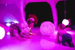 En kvinna kryper på en dansmatta med en bebis framför sig.