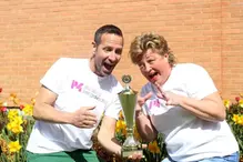 En man och en kvinna från Sveriges Radio som håller i en pokal ser glada ut.