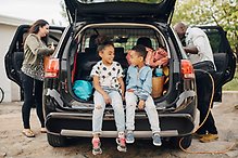Bild på en familj som håller på och packar sin bil.