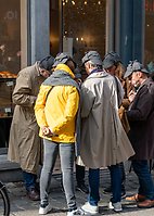 Några personer står på en gata och samtalar