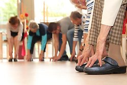 Seniorer utför sittande gymnastik inomhus