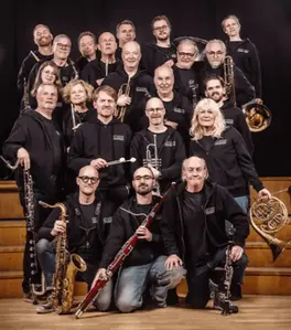 En stor grupp människor som håller i varsitt blåsinstrument.