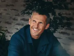 En man som tittar åt sidan och ler stort. 