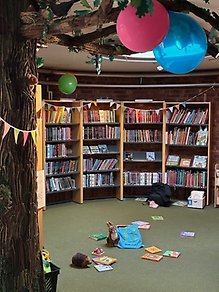 Bild från bibliotekets barnboksrum med ballonger, böcker och bokstartspåse.