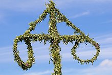 Närbild på en klädd midsommarstång.