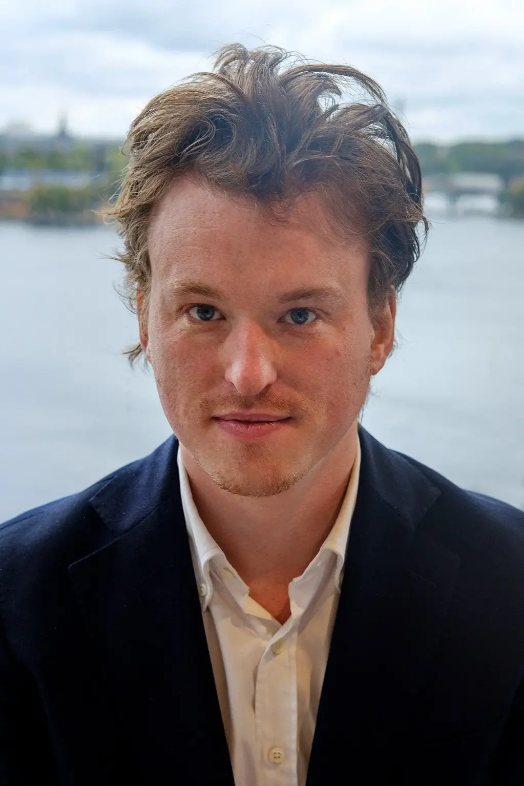 Man med ljust hår och skjorta och kavaj.