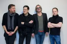 Fyra män som står bredvid varandra på rad. 